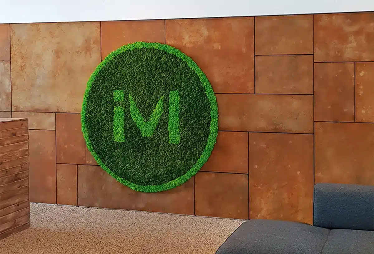 Green moss wall art with 'iM' logo