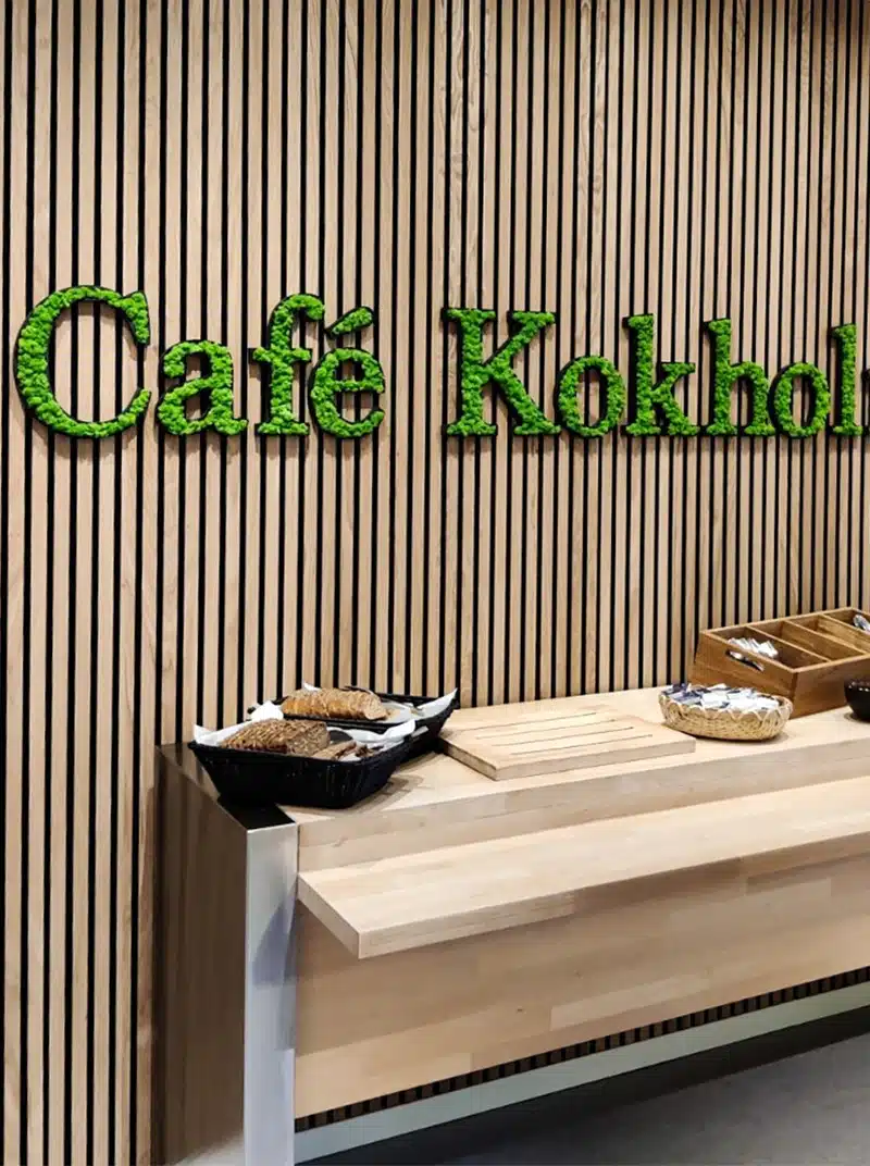 Café Kokholma sign on wooden wall, with pastries.